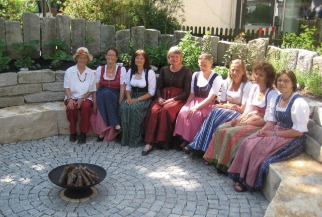 Die Kräuterpädagoginnen des Landkreises sitzen auf einer Mauer im Kräuterkreis in Wolfratshausen, © Stadt Wolfratshausen Die Kräuterpädagoginnen des Landkreises sitzen auf einer Mauer im Kräuterkreis in Wolfratshausen, © Stadt Wolfratshausen