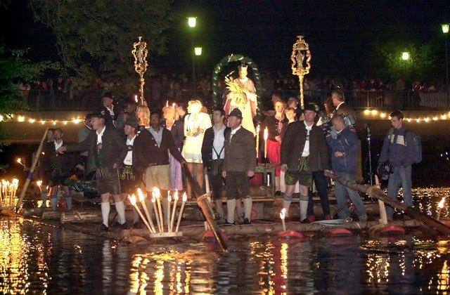 Flößer im Festgewand auf einem Floß in der Dunkelheit, das mit Fackeln beleuchtet ist, anlässlich der Johannifloßprozession., © Stadt Wolfratshausen Flößer im Festgewand auf einem Floß in der Dunkelheit, das mit Fackeln beleuchtet ist, anlässlich der Johannifloßprozession., © Stadt Wolfratshausen