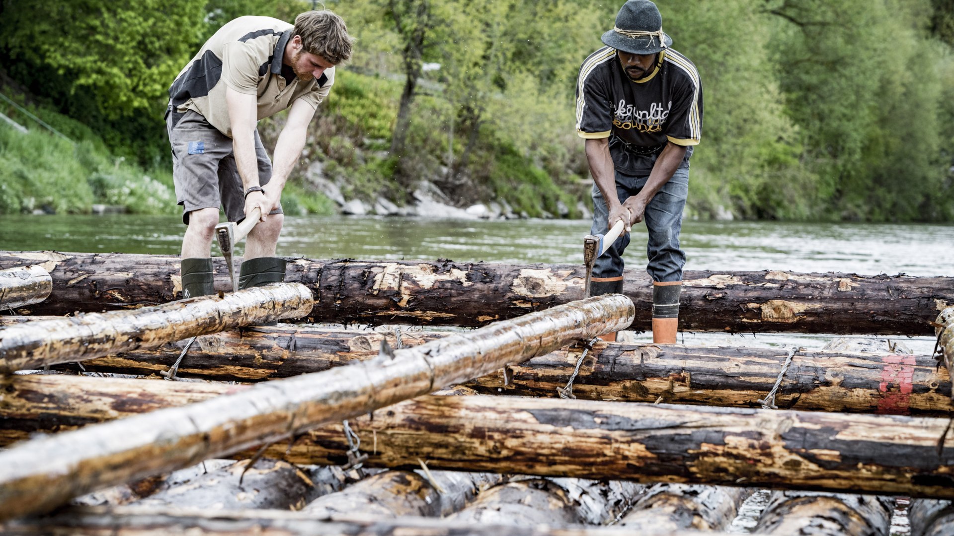 Zwei Männer bauen ein Floß für die Fahrt nach München auf der Isar., © Adrian Greiter Zwei Männer bauen ein Floß für die Fahrt nach München auf der Isar., © Adrian Greiter