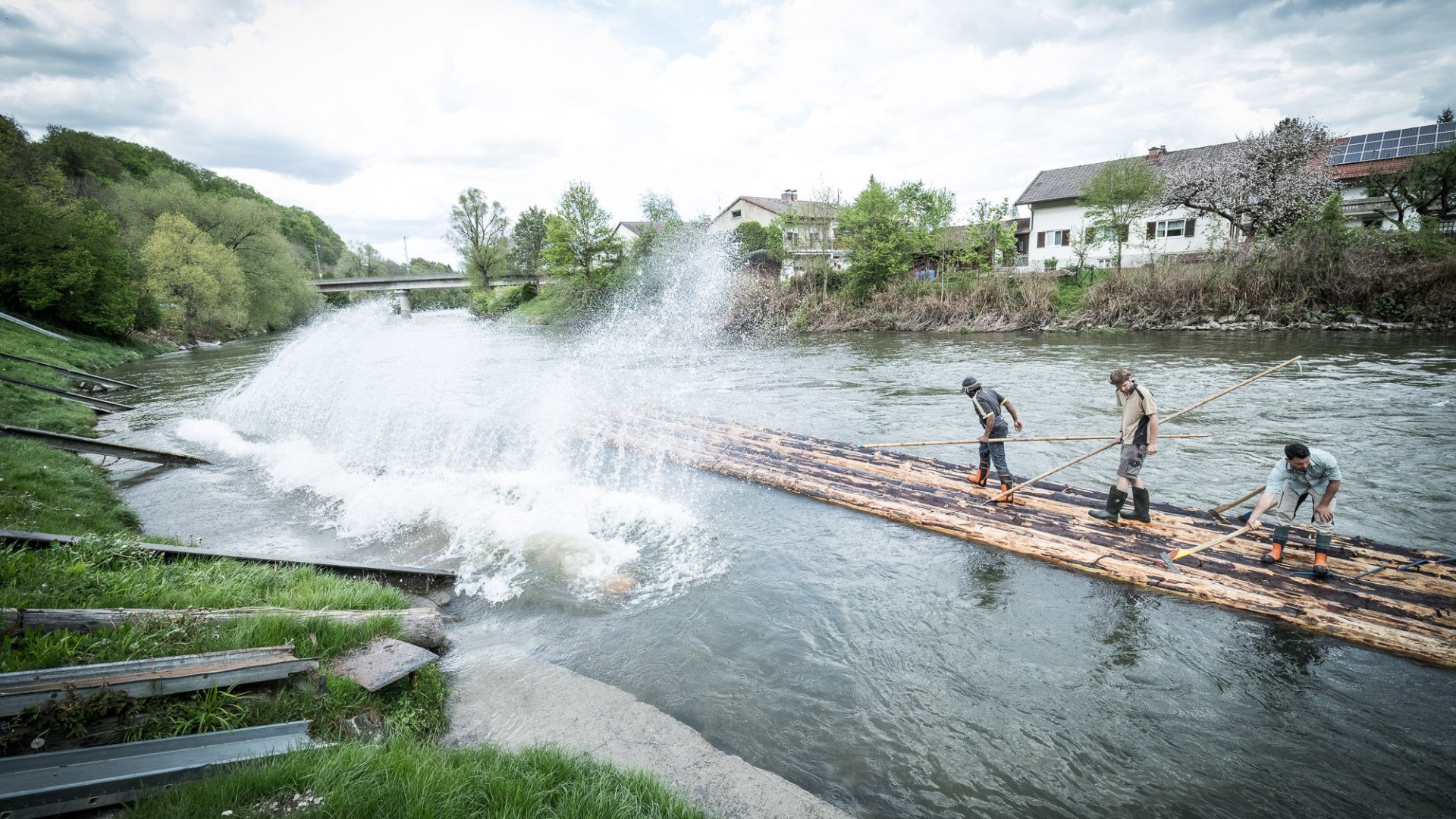 Flößer auf Stämmen im Wasser beim Floßbau, © Stadt Wolfratshausen, Adrian Greiter