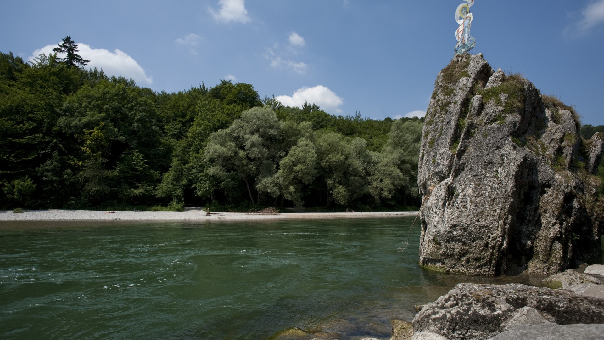 Die Isar im Sonnenschein mit blauem Himmel. Am rechten Bildrand ist der Georgenstein zu sehen, auf dem das Wappen steht. , © Stadt Wolfratshausen