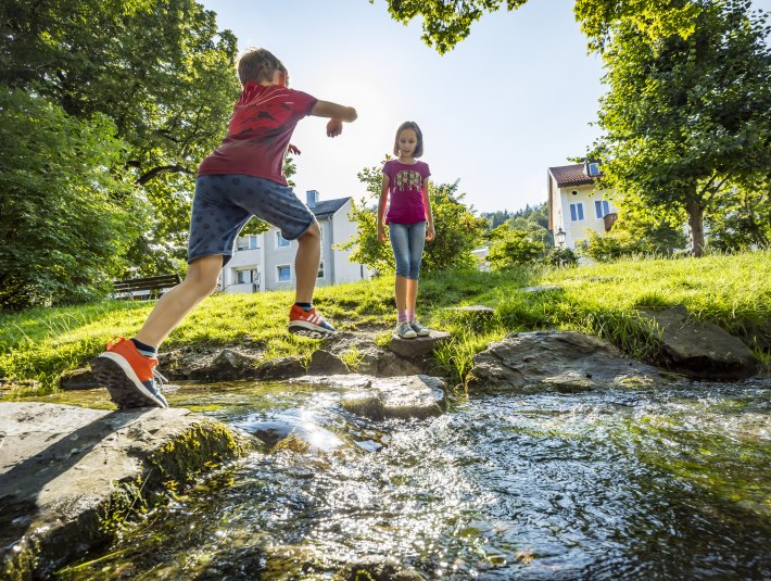 Zwei Kinder spielen an einem Bach im Japanischen Garten in Wolfratshausen, &copy; Stadt Wolfratshausen, Fotograf: Adrian Greiter