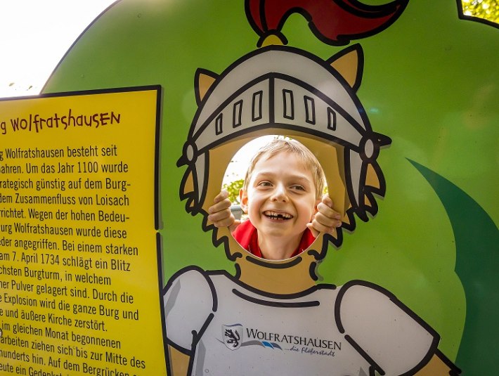 Unterwegs am Bergwald, ein Kind schaut durch eine Figur, die als Fotopoint dient, &copy; Adrian Greiter