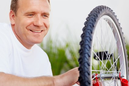 Ein Mann repariert ein Rad von einem Fahrrad, &copy; Stadt Wolfratshausen