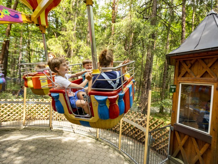 Zwei Kinder im Karssel im M&auml;rchenwald, &copy; Stadt Wolfratshausen, Fotograf: Adrian Greiter