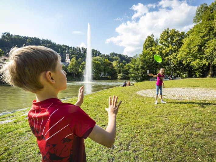 Ein Kind steht vor der einer Fontäne auf einer Wiese, © Adrian Greiter