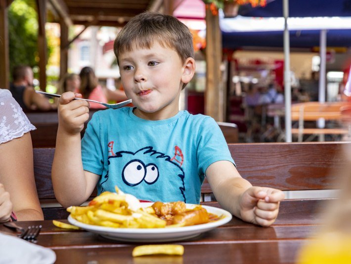 Ein Junge genießt seine Pommes im Märchenwald-Restaurant, © Stadt Wolfratshausen, Fotograf: Adiran Greiter